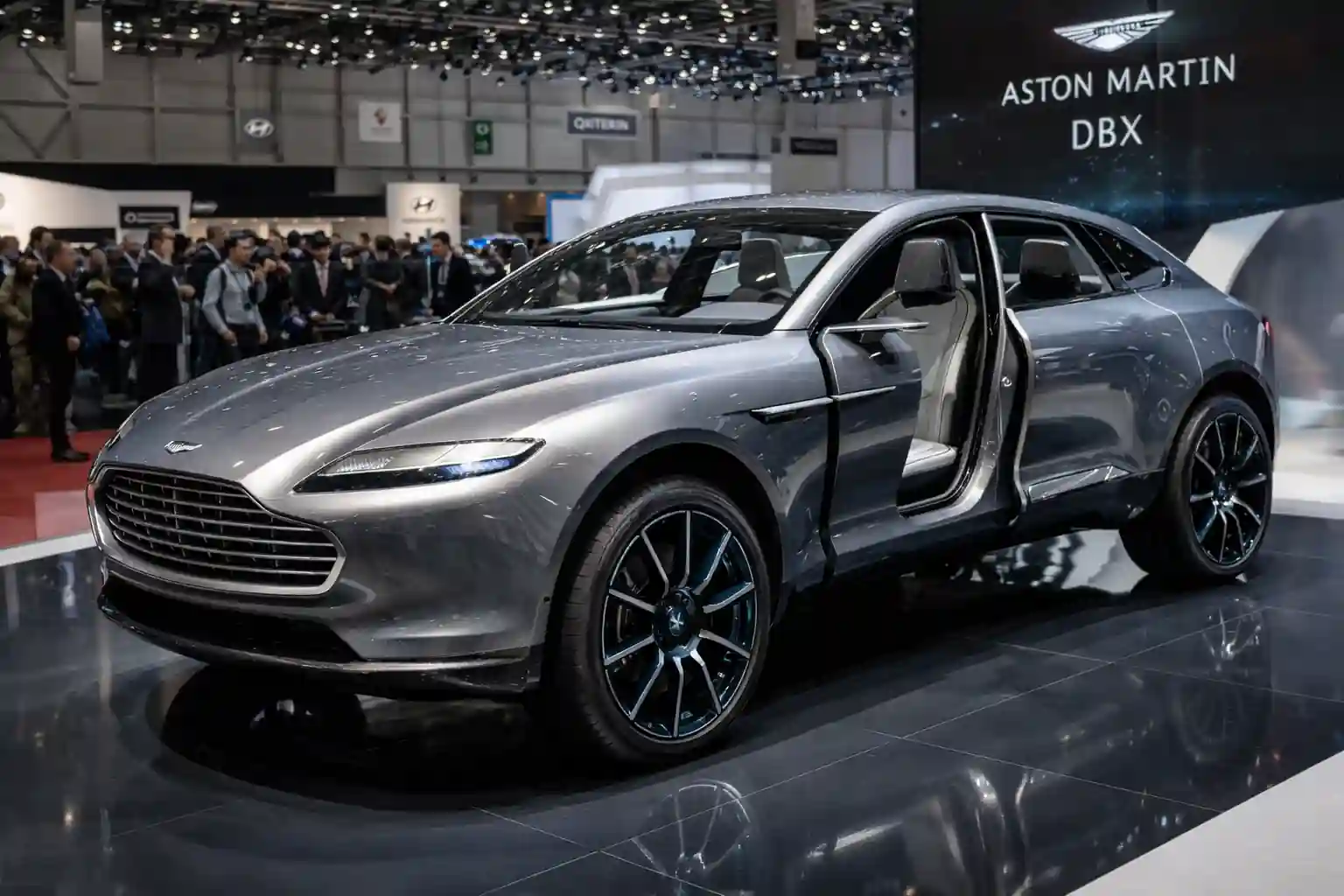 Aston Martin DBX Concept présenté au salon de Genève 2015 avec design crossover fastback et portes antagonistes ouvertes sur le stand du constructeur britannique
