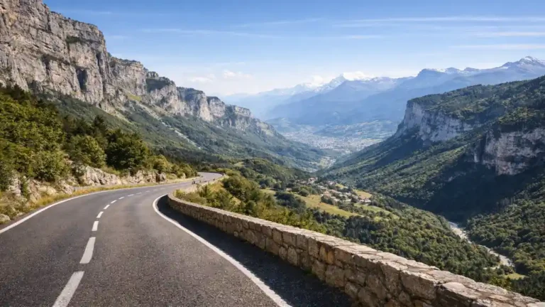 Route panoramique du Vercors entre Die et Seyssinet-Pariset longeant des falaises calcaires avec vue sur la vallée et les montagnes alpines autour de Grenoble.