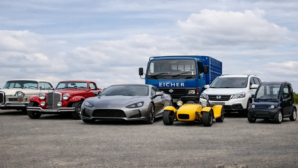 Plusieurs véhicules anciens, utilitaires et électriques alignés pour illustrer les marques automobiles commençant par la lettre E